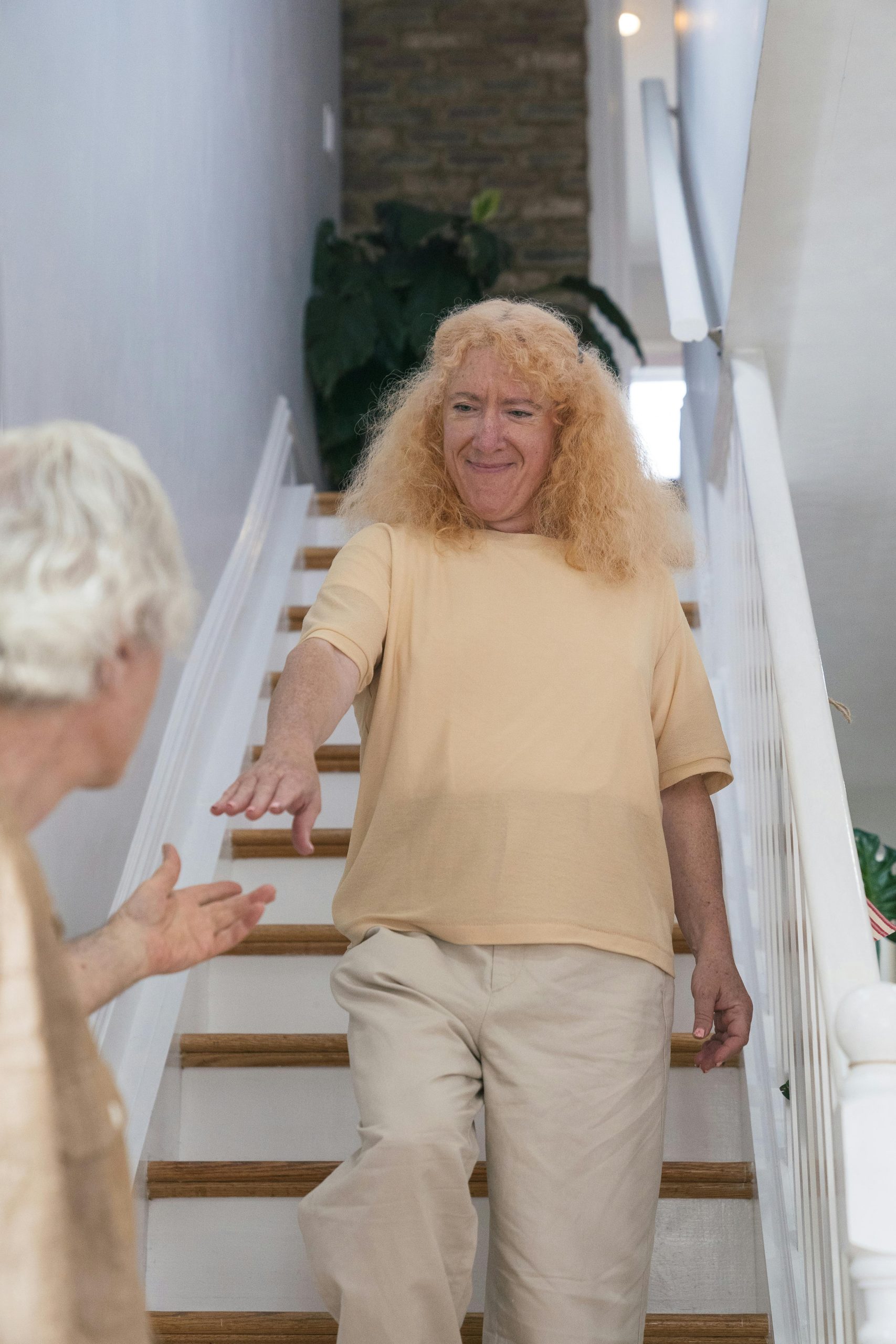 cuidadora ayudando a adulto mayor a bajar escaleras para prevenir eventos adversos en el cuidado domiciliario